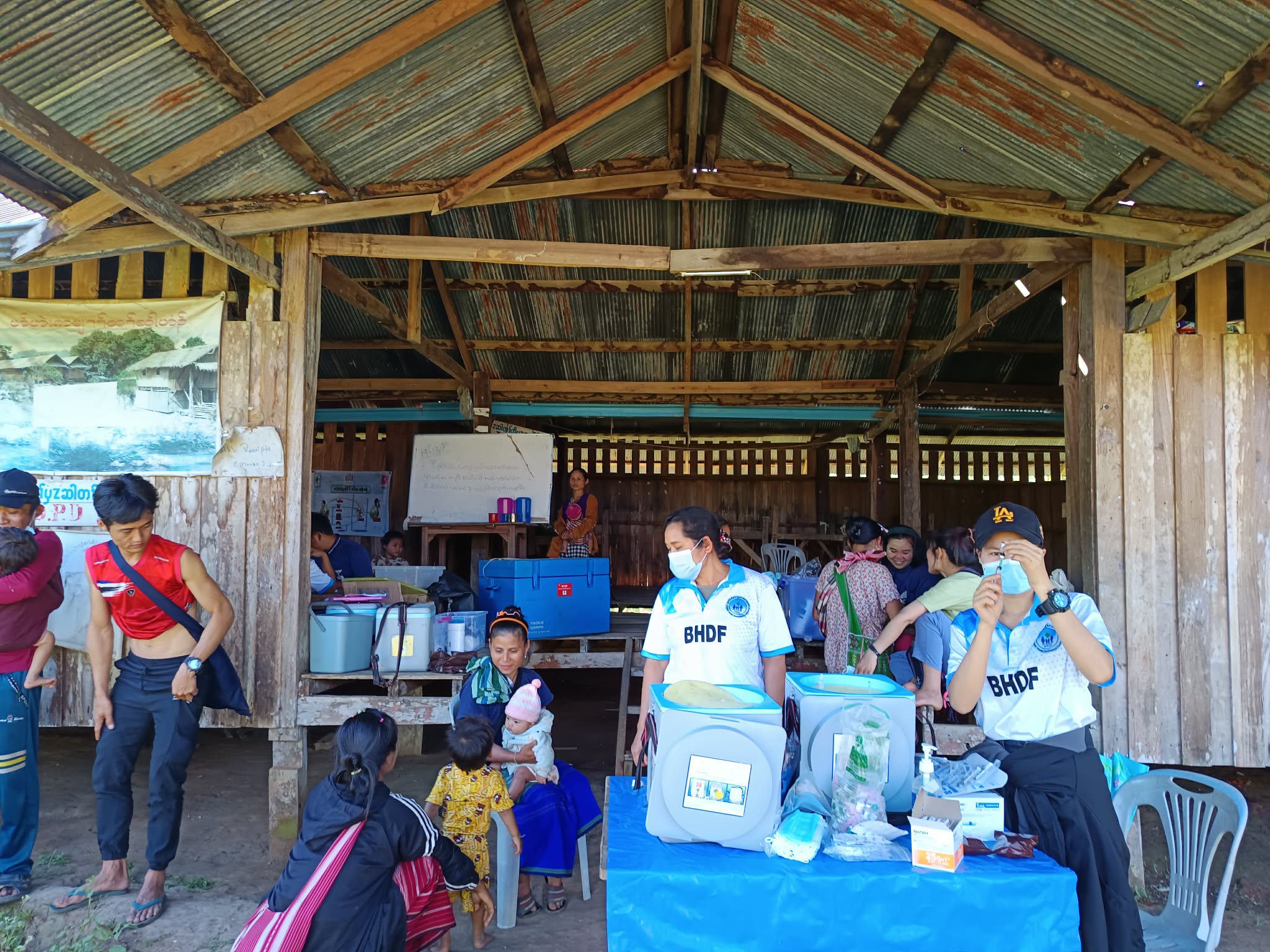 Health worker vaccinating a child at a village clinic
